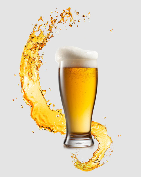 Splashing wave and big glass of fresh light beer on a light gray background with copy space. Octoberfest concept. - Foto, imagen