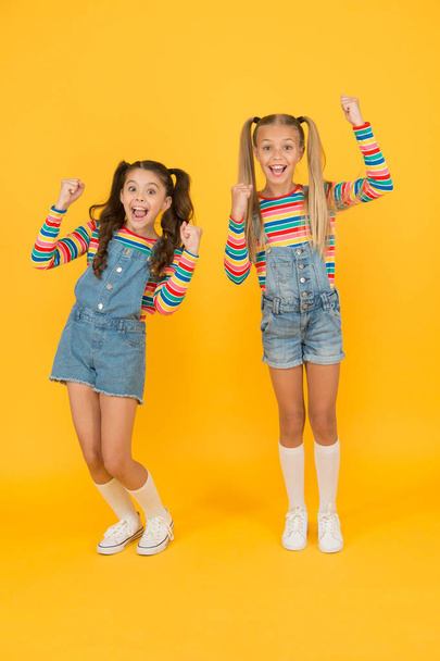 Matching outfits. Fashion shop. Must have accessory. Vibrant colors. Modern fashion. Kids fashion. Girls long hair. Cute children same outfits. Trendy and fancy. Little girls wearing rainbow clothes - Zdjęcie, obraz