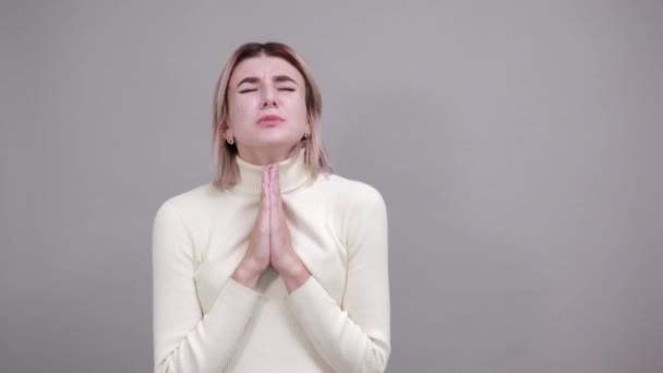 Portrait of woman looking down, holding hands crossed, praying - Footage, Video