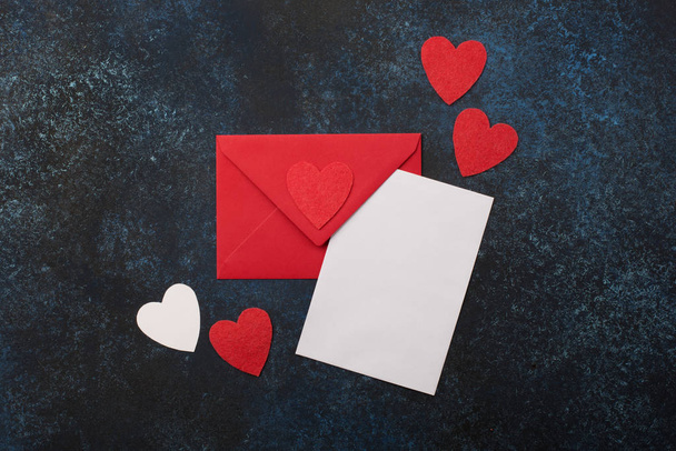 Üres kártya piros borítékkal és szívekkel. - Fotó, kép