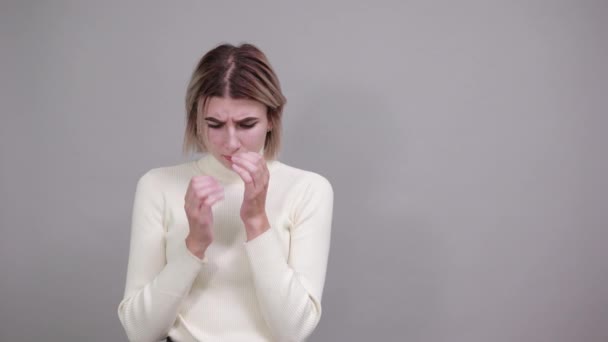 Mujer rubia joven con expresión facial sorpresa, cubriendo la boca con las manos
 - Metraje, vídeo