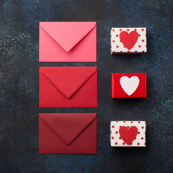 Rode enveloppen, geschenken en rode harten op klassieke blauwe achtergrond. - Foto, afbeelding