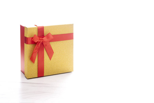 Caja de regalo brillante de oro y rojo con cinta de regalo y lazo
 - Foto, imagen