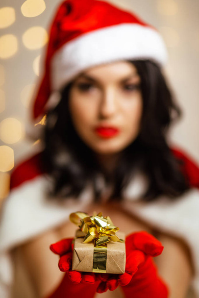beautiful sexy girl wearing santa claus clothes with christmas gift - Valokuva, kuva