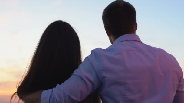 Mann umarmt zärtlich Frau zeigt mit dem Finger auf Distanz, Vergnügen Zeitvertreib open air - Filmmaterial, Video