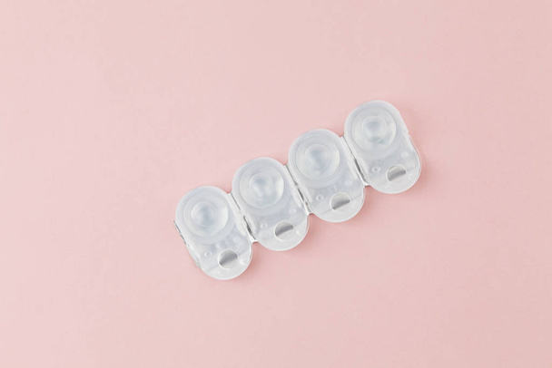 Contact lens packages a pink background. Stack of healthcare disposable contact lens. Flat lay composition - Foto, Imagem