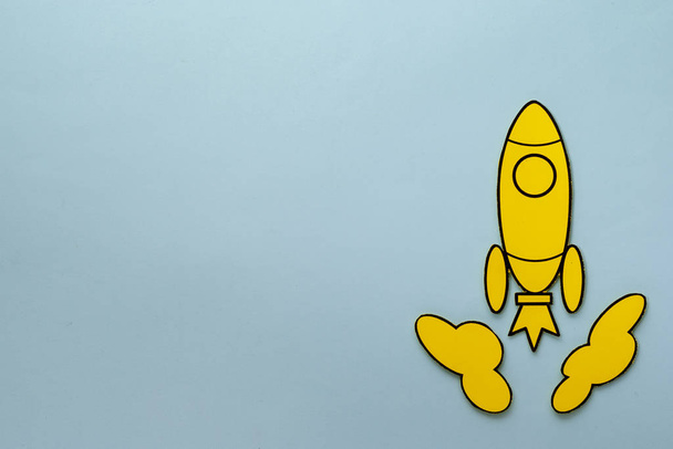 Cohete amarillo de dibujos animados acercándose a través del espacio un fondo azul
 - Foto, imagen