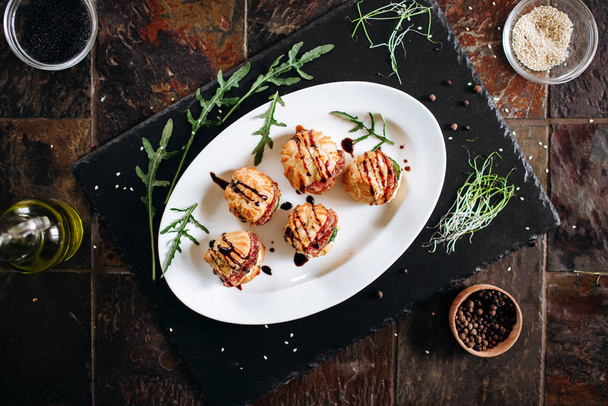 Ciasto francuskie z salami i sosem balsamicznym podawane na talerzu z ziołami - Zdjęcie, obraz