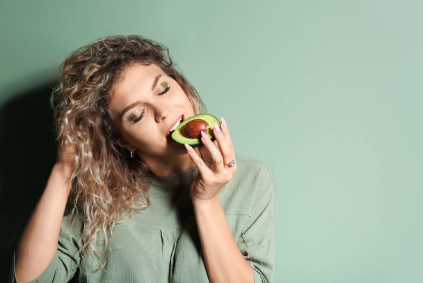 Fashionable young woman with avocado on color background - Zdjęcie, obraz
