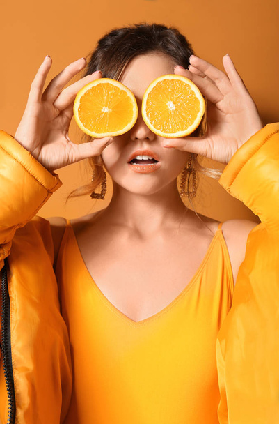 Fashionable young woman with lemon on color background - Photo, Image