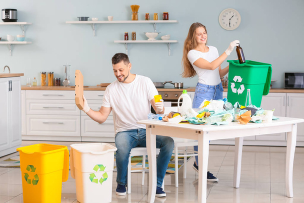 Ζευγάρι διαλογή σκουπίδια στο σπίτι. Έννοια της ανακύκλωσης - Φωτογραφία, εικόνα