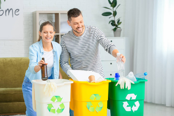 Couple sorting garbage at home. Concept of recycling - Foto, afbeelding
