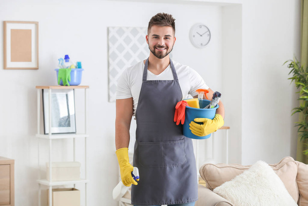 Muž údržbář s čisticími prostředky na pokoji - Fotografie, Obrázek
