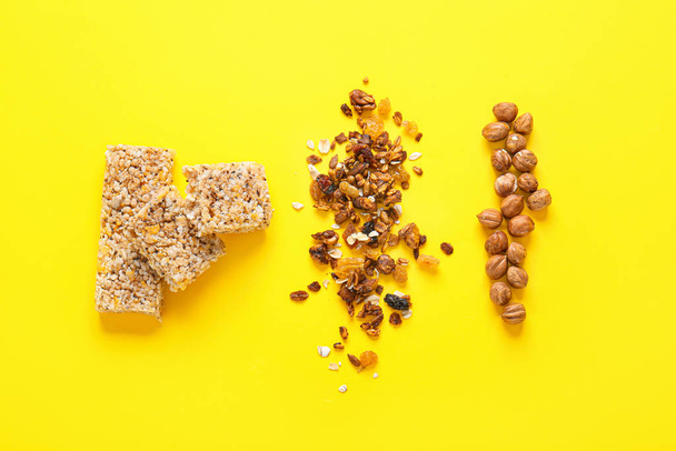 Tasty granola bars with ingredients on color background - Photo, image