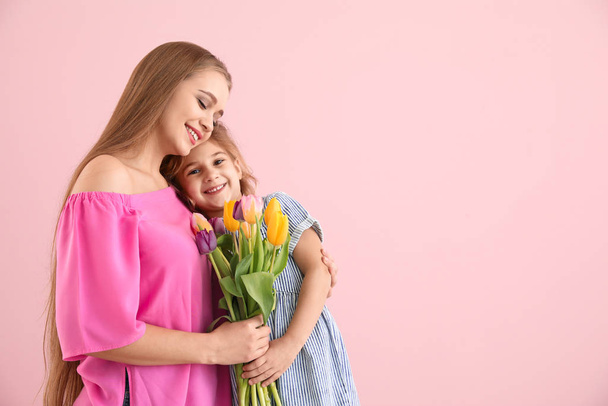 kleines Mädchen grüßt ihre Mutter auf farbigem Hintergrund - Foto, Bild