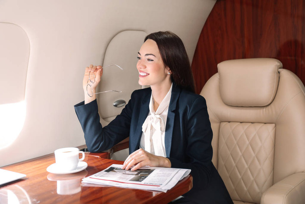 Bizneswoman na pokładzie nowoczesnego prywatnego samolotu - Zdjęcie, obraz