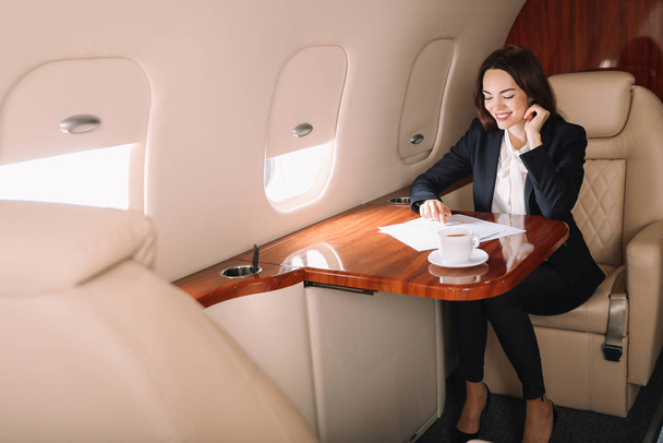 Businesswoman on board the modern private airplane - Photo, Image