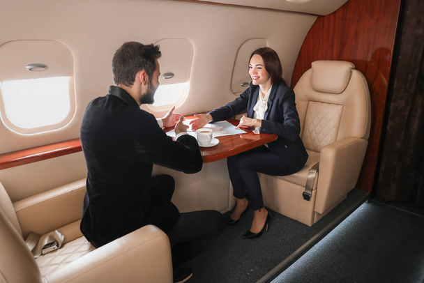 Business colleagues on board the modern private airplane - Фото, изображение