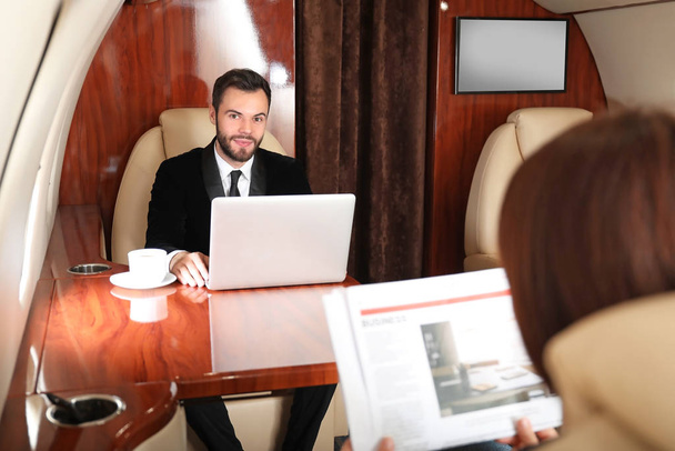 Business colleagues on board the modern private airplane - 写真・画像