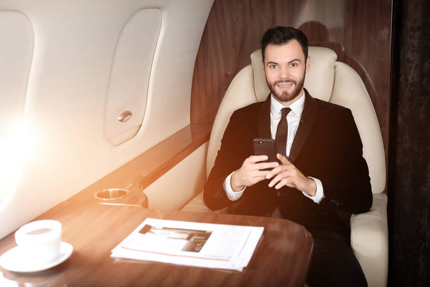 Businessman on board the modern private airplane - 写真・画像