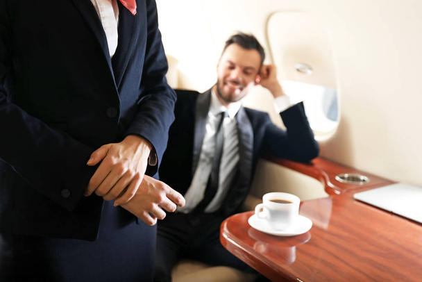 Hostess aerea e uomo d'affari a bordo del moderno aereo privato
 - Foto, immagini