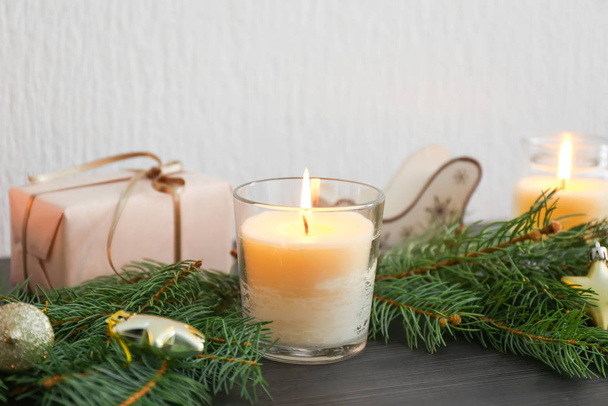 Mooie brandende kaarsen, kerstdecor en dennentakken op tafel - Foto, afbeelding