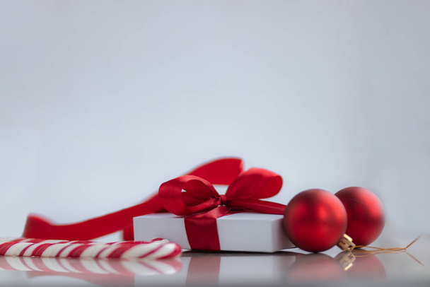 weiße Geschenkbox mit rotem Band Süßigkeiten und Dekorationen auf weißem Hintergrund. Weihnachts- und Neujahrsferien-Konzept. - Foto, Bild