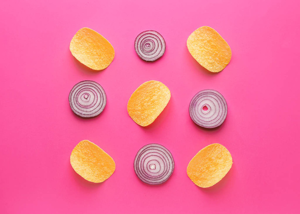Tasty potato chips and onion on color background - Foto, immagini