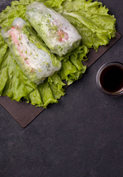 Spring rolls with on a green plate next to a gray sauce on a black background. have copy space. vegetarian dish - Fotografie, Obrázek