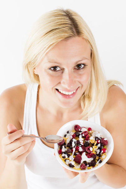 Happy blonde woman eating muesli - Fotó, kép