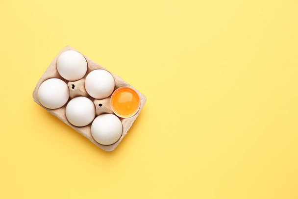 Box with fresh raw eggs on color background - Fotó, kép