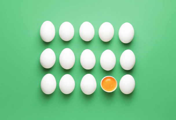Rozbité vejce mezi celými na barevném pozadí. Koncept jedinečnosti - Fotografie, Obrázek