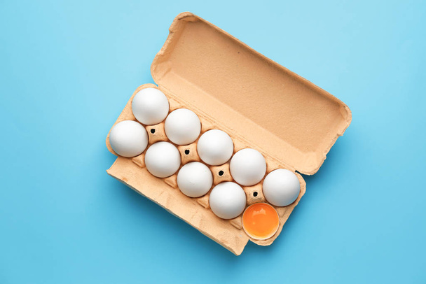 Box with fresh raw eggs on color background - Fotoğraf, Görsel