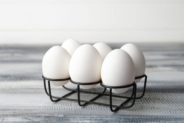 テーブルの上に新鮮な生の卵とホルダー - 写真・画像