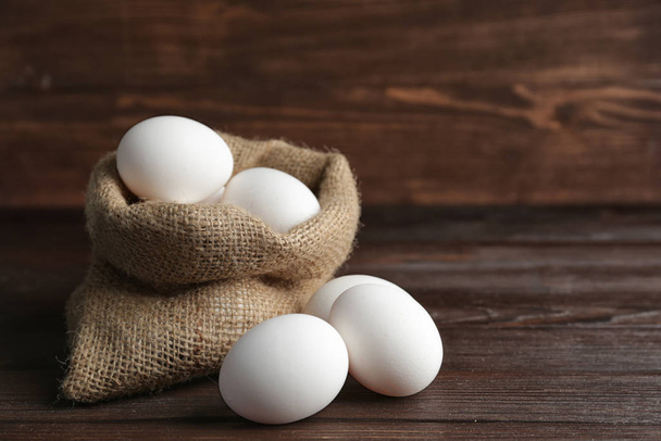 Сумка со свежими сырыми яйцами на столе
 - Фото, изображение