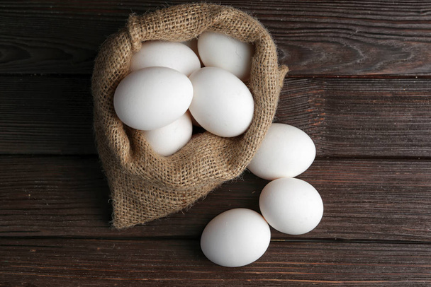 Sacchetto con uova fresche crude in tavola
 - Foto, immagini