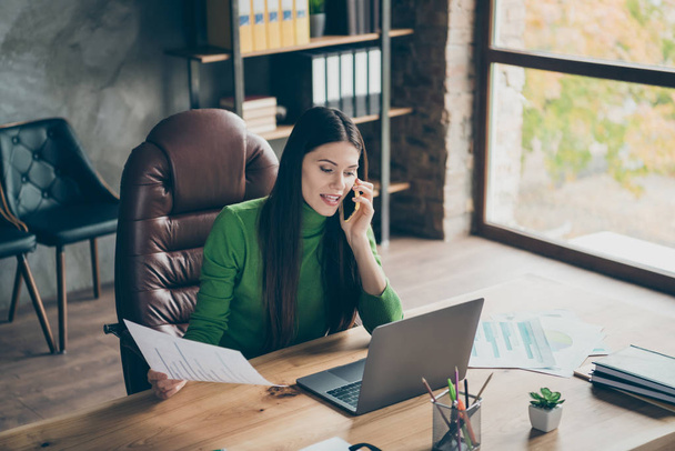Photo of pretty business lady speak telephone partners important company startup investment question wear green turtleneck sitting chair modern interior office - 写真・画像