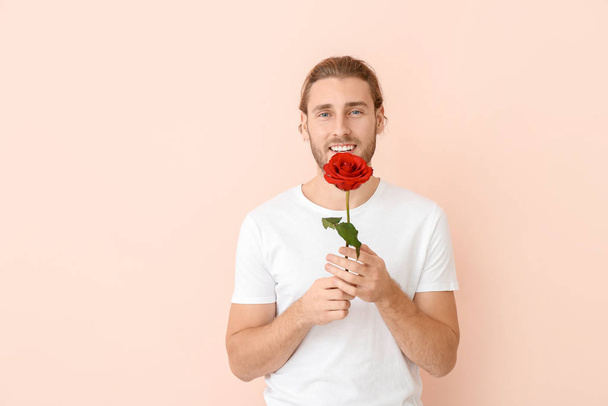 Renkli arka planda çiçek olan yakışıklı bir adam. Sevgililer Günü kutlaması - Fotoğraf, Görsel