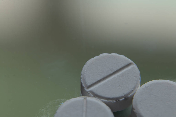 Макрозйомка, білі круглі медичні таблетки на склі
 - Фото, зображення