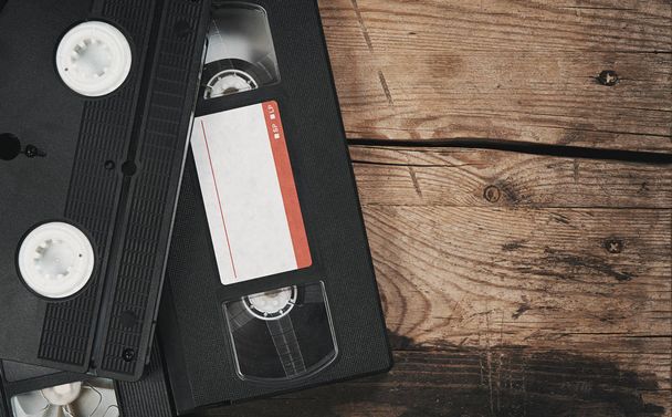 stack of VHS video tape cassettes over wooden background - Zdjęcie, obraz