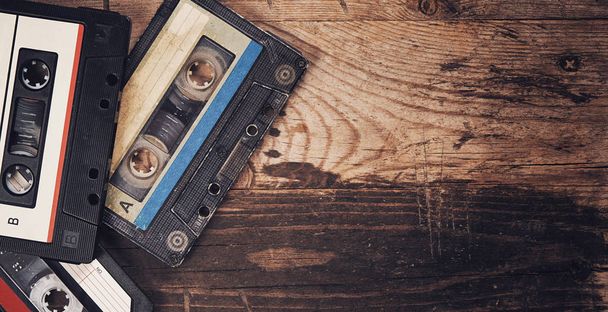 Old audio tape compact cassette on wooden background - Photo, image