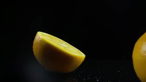 Κομμένα πορτοκάλια πέφτει αυγή σε μαύρο φόντο, αργή κίνηση - Πλάνα, βίντεο