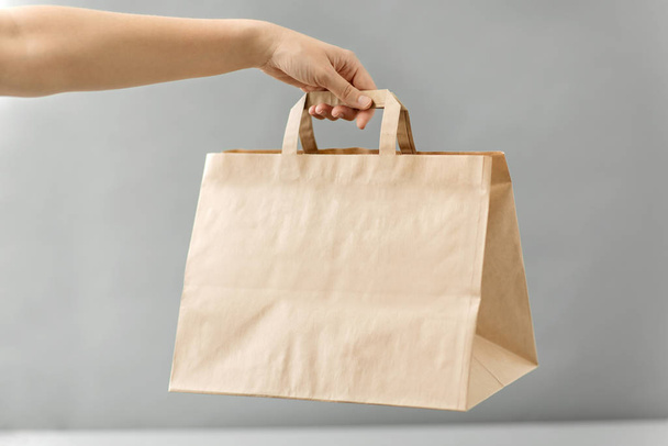 hand holding takeaway food in paper bag with lunch - Foto, Bild