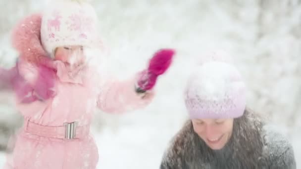 Woman and child playing with snow in winter - Video