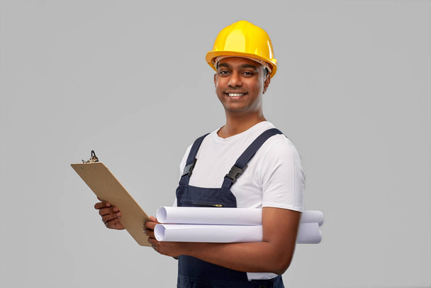 happy indian builder with blueprint and clipboard - Foto, Imagen