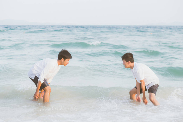 Homosexual retrato joven asiático pareja jugar agua en playa con
  - Foto, imagen