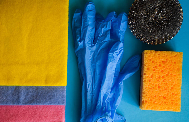Cleaning and cleaning accessories, Gloves, sponges on a blue background. Cleaning Service Concept. Banner. Copy space. Flat lay, Top view. - Photo, Image