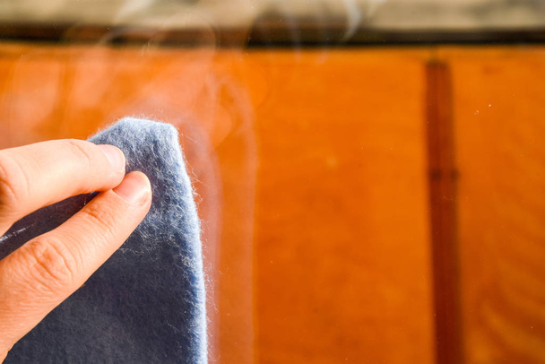 ほこりから壁を拭くマイクロ繊維布でゴム保護手袋で従業員の手。商業用洗浄会社の概念早春の洗浄または定期的なクリーンアップ. - 写真・画像