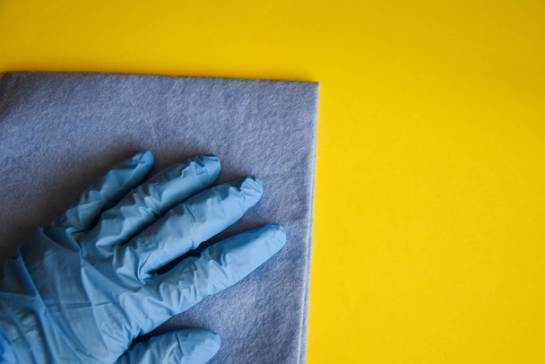 Ręka pracownika w gumowej rękawicy ochronnej z mikro tkaniny włóknistej wycierania ściany z kurzu. Komercyjne sprzątanie koncepcji firmy Wczesne wiosenne sprzątanie lub regularne sprzątanie. - Zdjęcie, obraz
