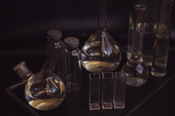 Set con diversi bicchieri da laboratorio e liquido per analisi su sfondo nero Apparecchiature da laboratorio di chimica del vetro su sfondo nero. Concetto di laboratorio di chimica
 - Foto, immagini